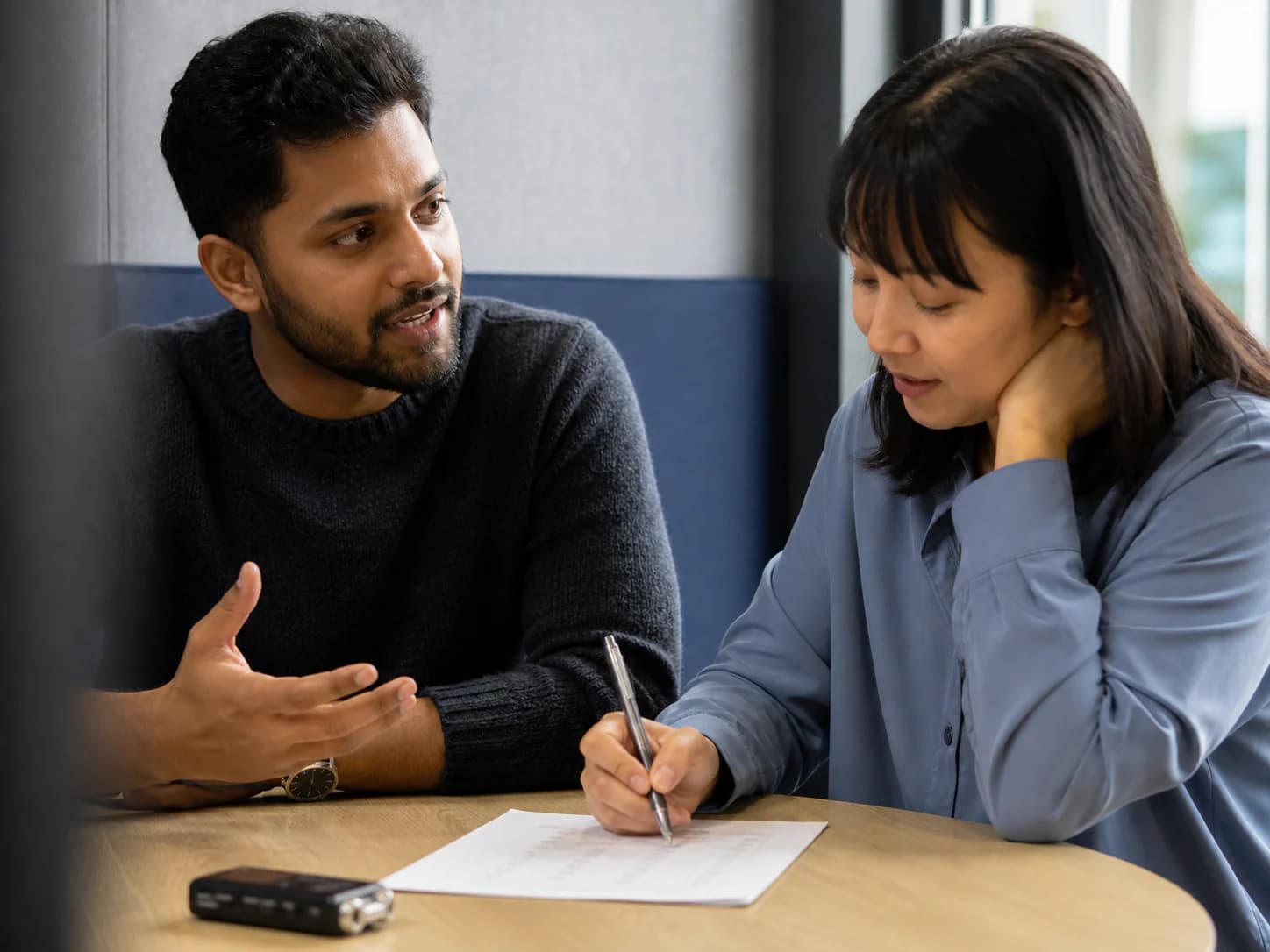 Two adult learners practise careful speaking and listening at a quiet study table